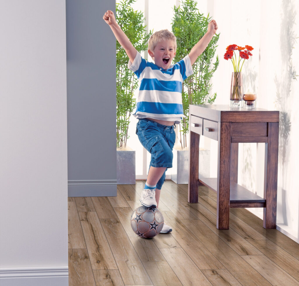 Young boy playing soccer on Elka Salvaged Oak floors